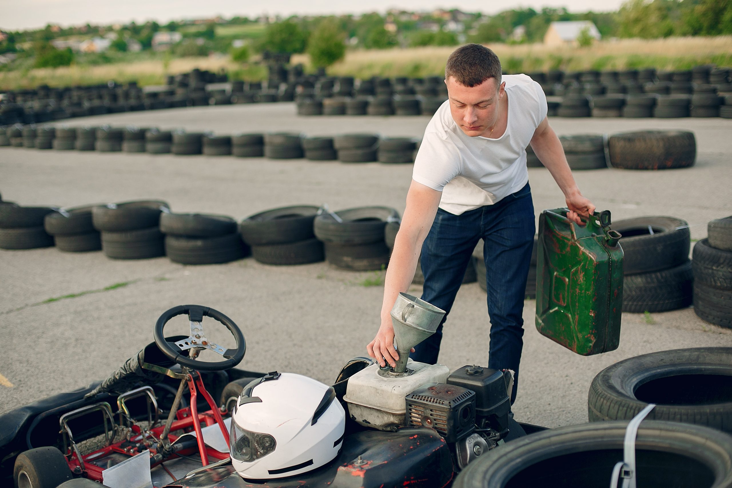 Karting. Man in a white t-shirt. Male refills a car